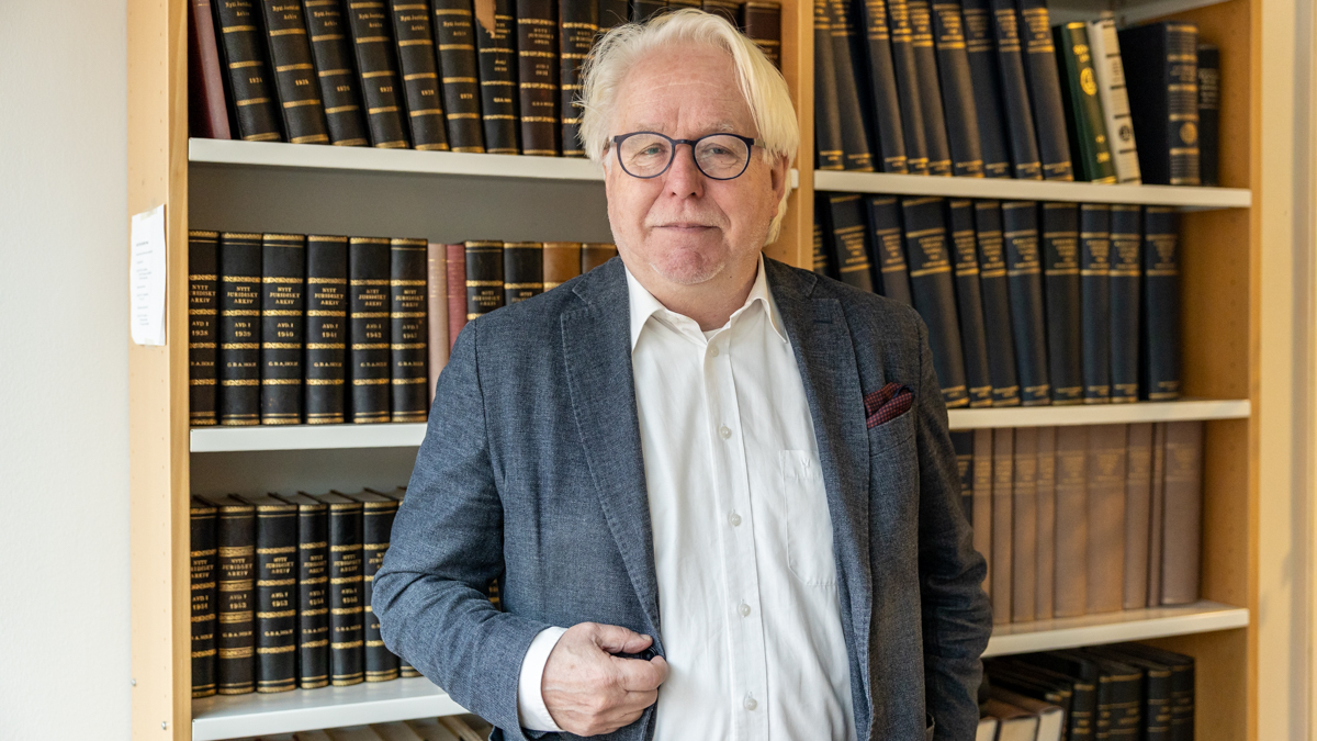 Jukka Kekkonen takanaan hylly täynnä lakikirjoja.