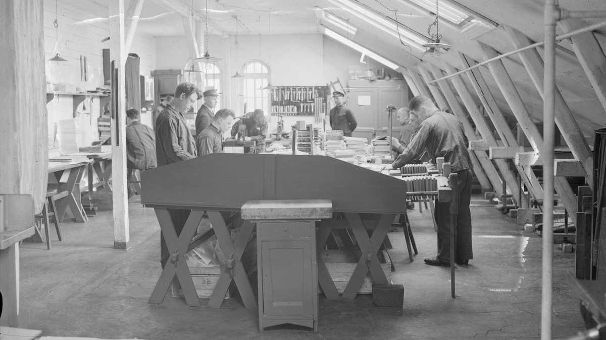 Mustavalkoisessa kuvassa vangit työskentelevät vartijoiden valvonnassa.