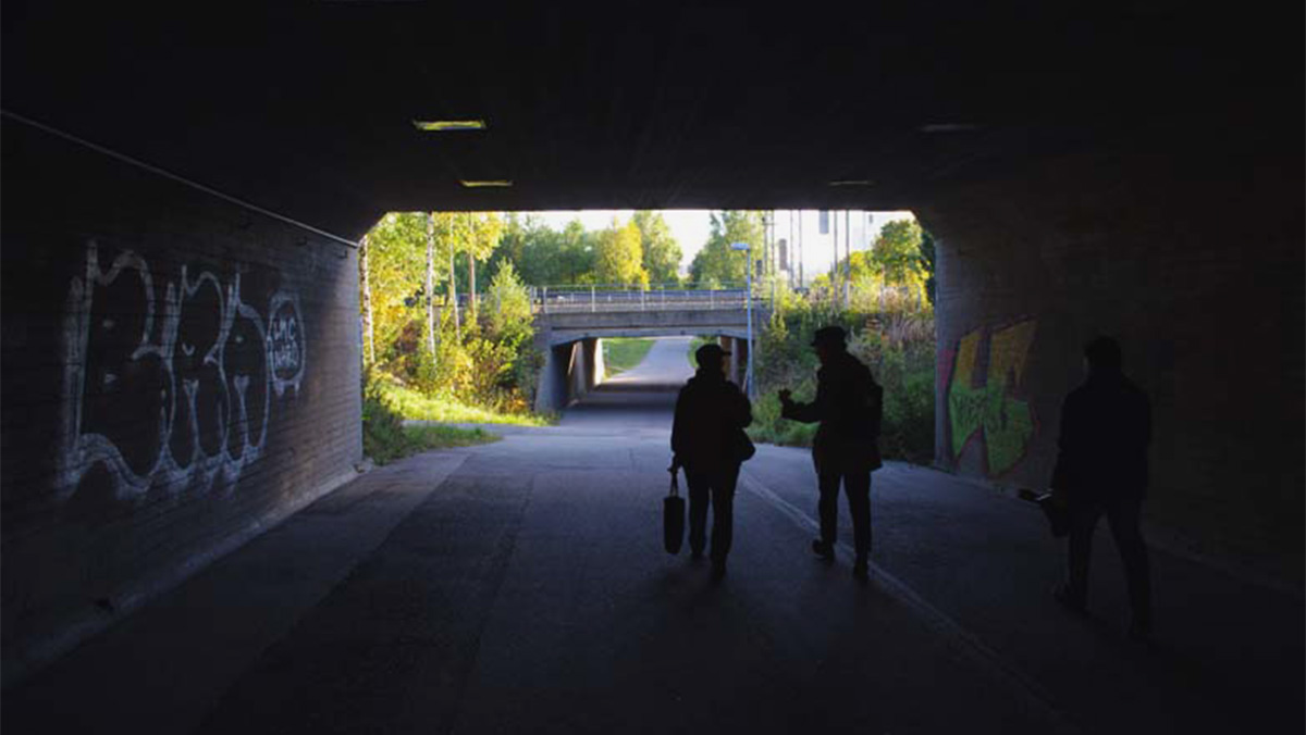 Människor i en mörk gångtunnel.