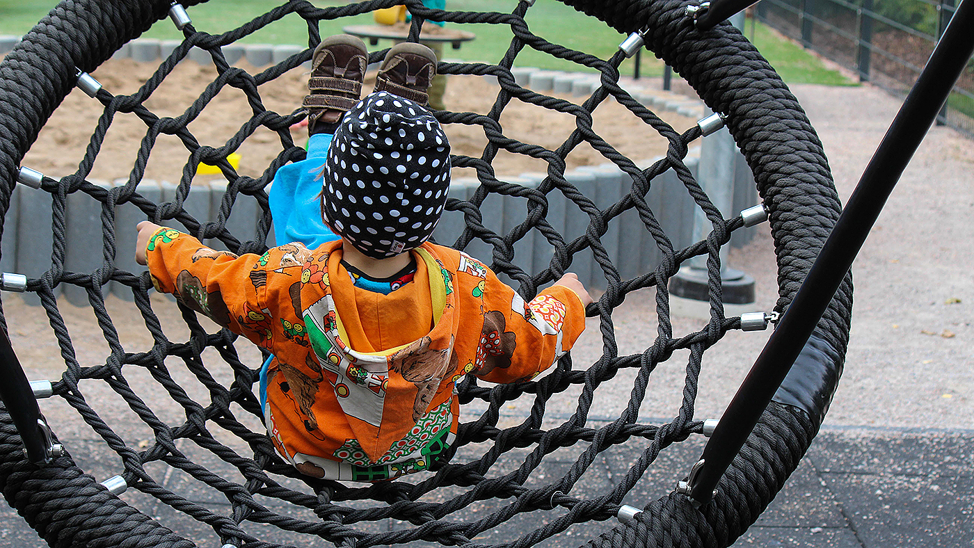 Lapsi verkkokeinussa takaapäin.