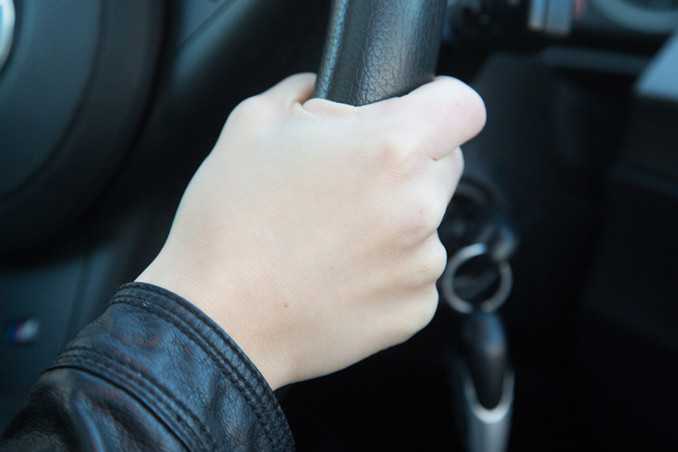 Nuoren käsi ja ratti.