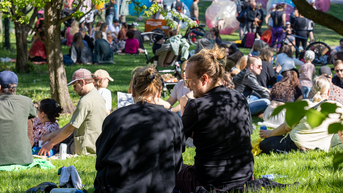 Stadsdelsfesten i Helsingfors, människor på gräsmattan.