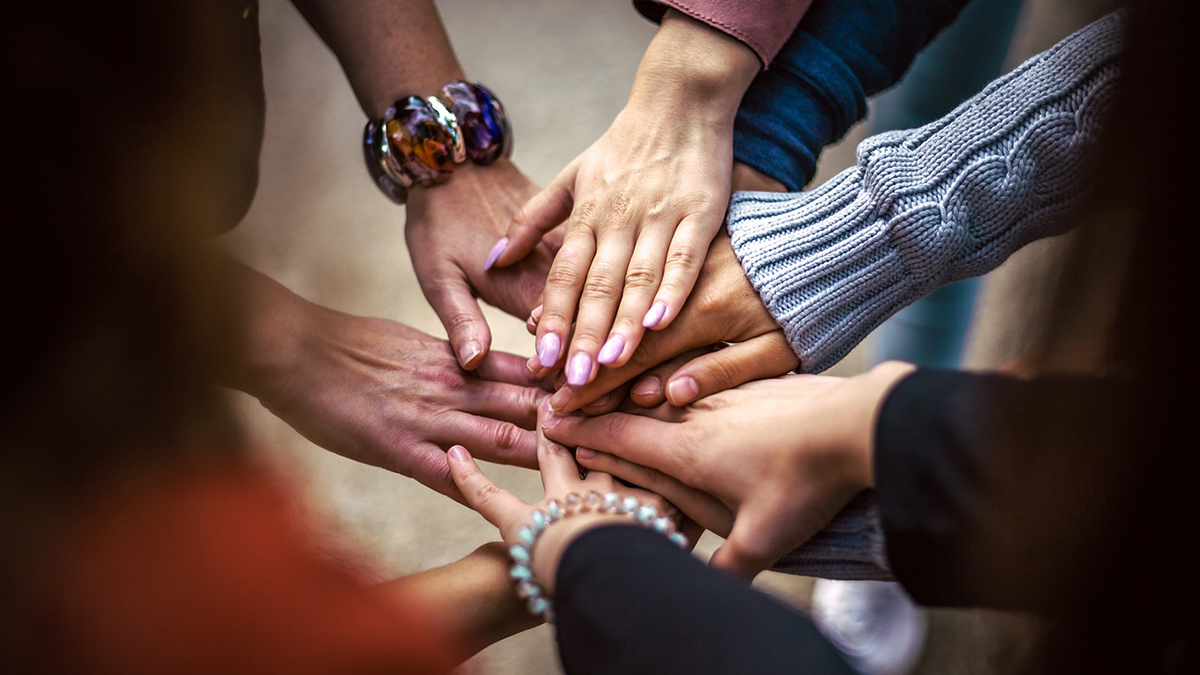 Eri ikäisten ihmisten yhteenliitetyt kädet.